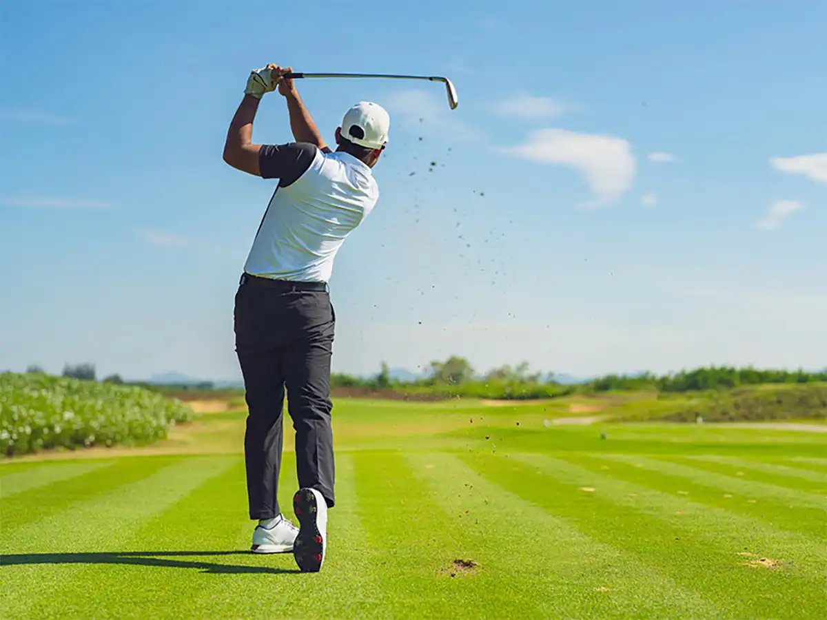 A man swinging a golf club at Atoka Trails Golf Course